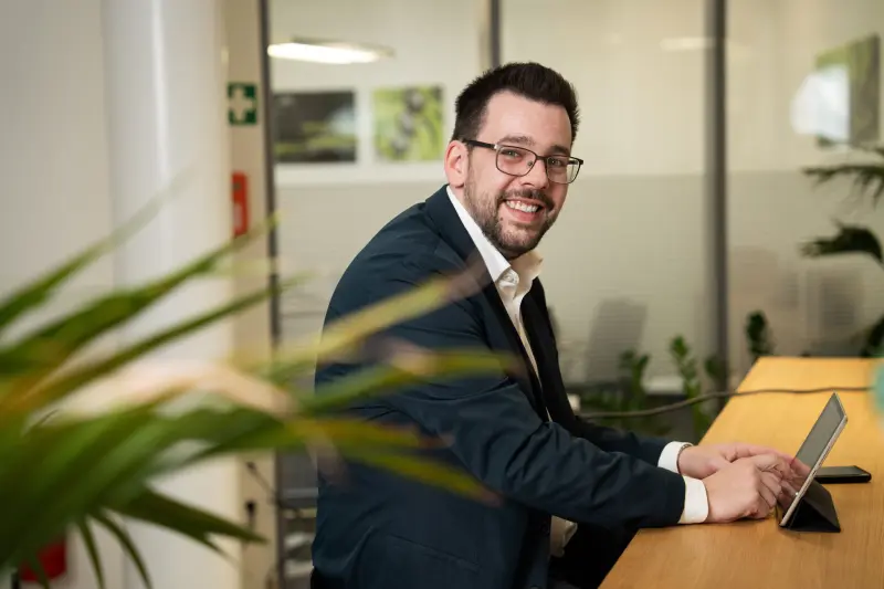 Eine Person hat ein Tablet vor sich und blickt in Richtung des Fotografen